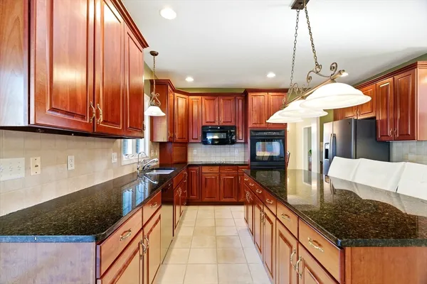 a kitchen with stainless steel appliances granite countertop a stove top oven a sink dishwasher and cabinets with wooden floor