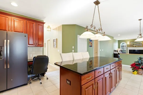 a kitchen with stainless steel appliances granite countertop a sink dishwasher and a refrigerator with wooden floor