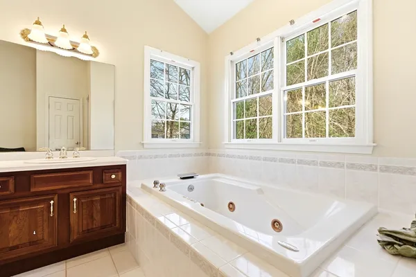 a bathroom with a tub a sink and a window