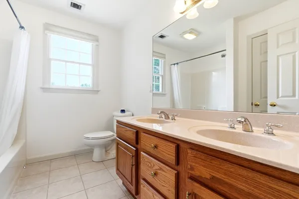 a bathroom with a granite countertop sink toilet and mirror