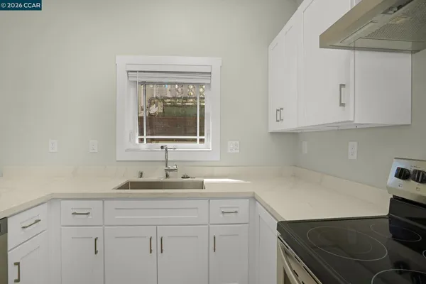 a kitchen with a sink cabinets and a stove top oven