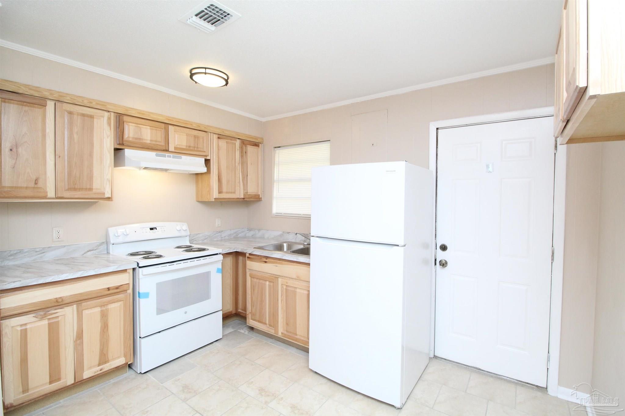 6620 Applegate Street Milton, FL 32570 - Photo 6 of 12 a kitchen with white cabinets and white appliances