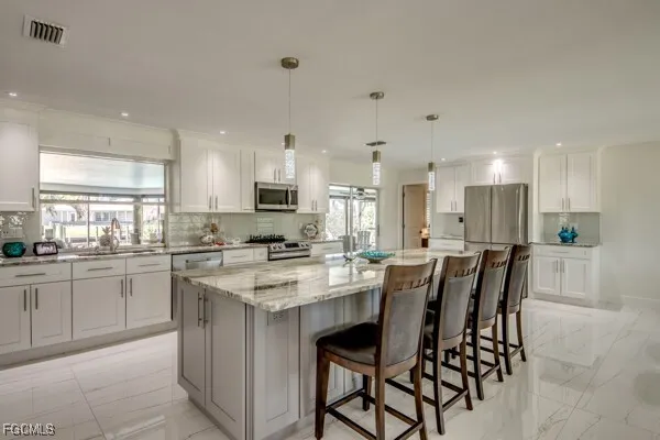 a kitchen with appliances a sink a counter space and a center island