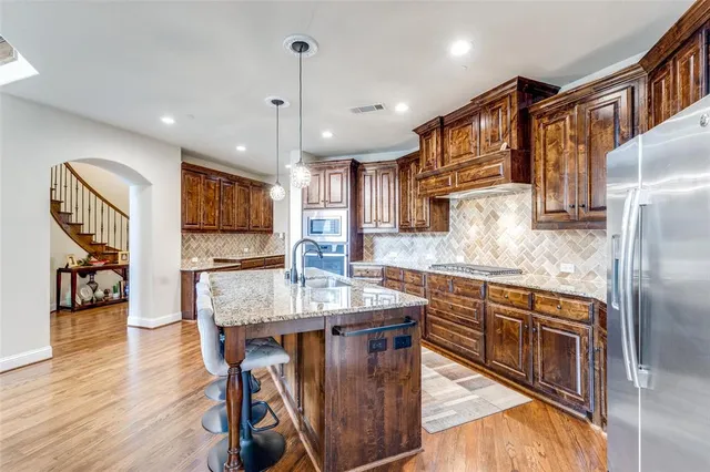 a kitchen with a table chairs refrigerator and cabinets