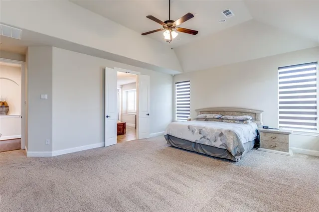 a spacious bedroom with a bed and a chandelier