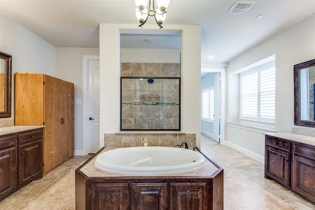 a spacious bedroom with a bed and a chandelier