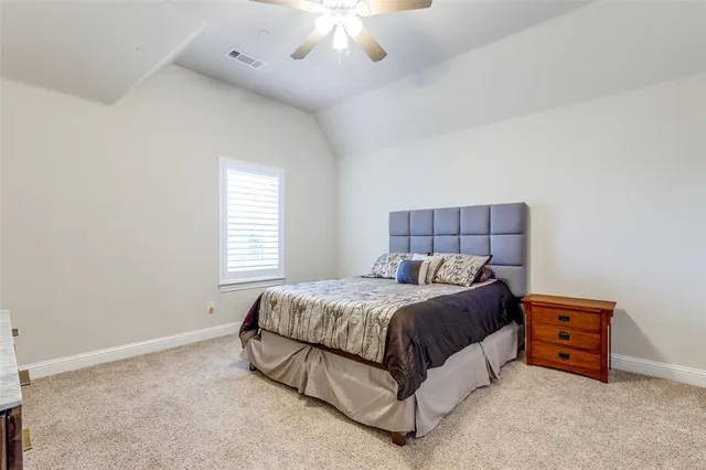 a spacious bedroom with a bed and a chandelier