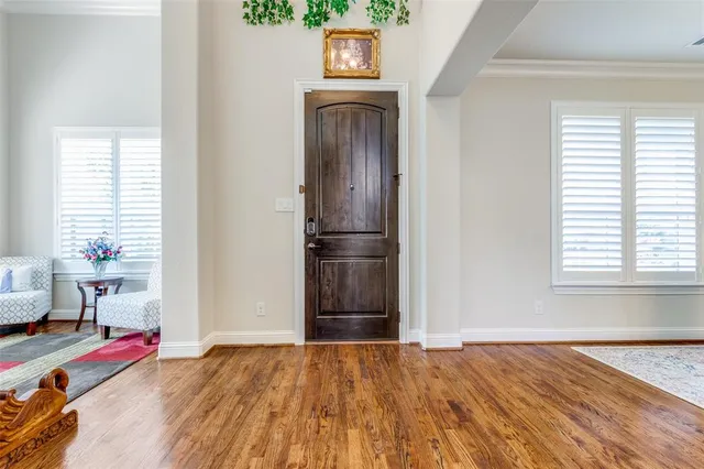 a view of empty room with wooden floor and window