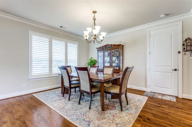 a view of a dining room with furniture a chandelier and wooden floor