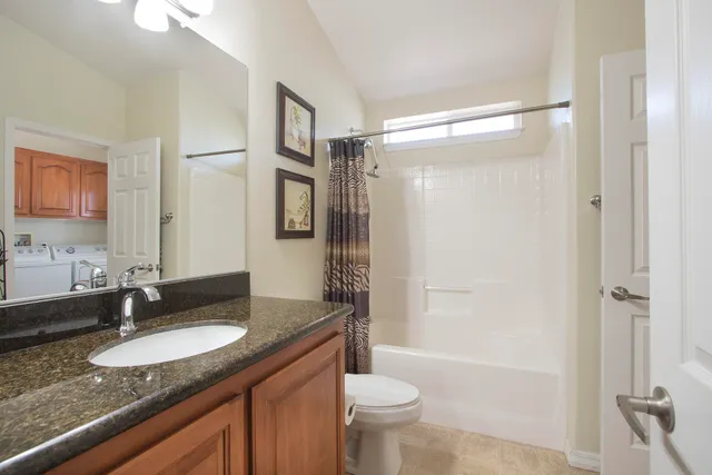 a bathroom with a granite countertop sink toilet and shower