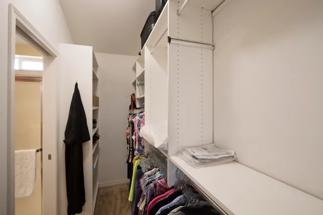 a view of walk in closet with clothes
