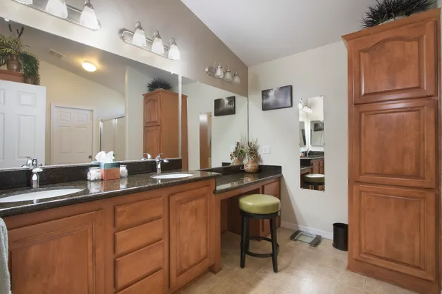 a spacious bathroom with a granite countertop sink and a mirror