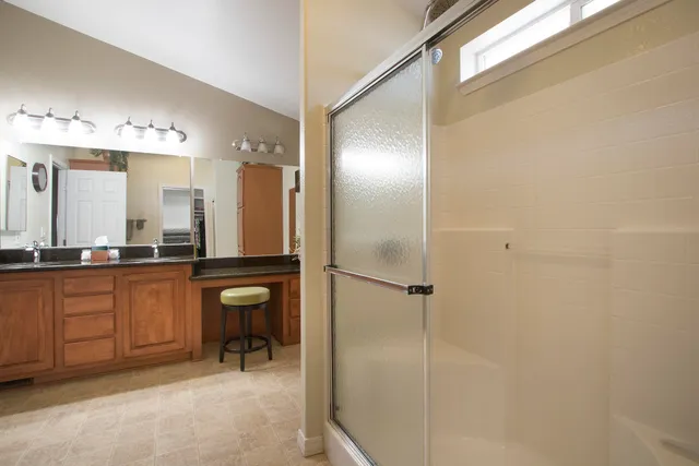 a bathroom with a sink mirror and a shower