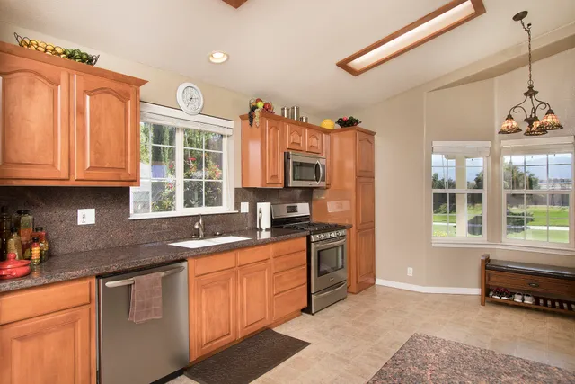 a kitchen with granite countertop a stove a sink and a cabinets