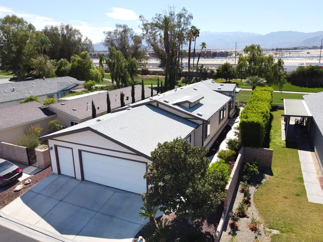 an aerial view of a house with a garden and lake view