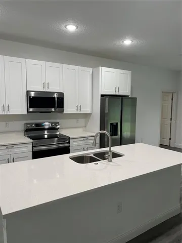 a kitchen with kitchen island granite countertop a sink and a stove