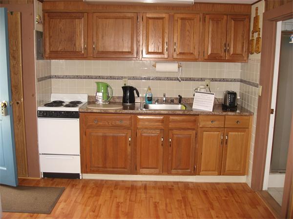 178 Captain Chase Road, Unit 12 Dennis, MA 02639 - Photo 3 of 4 a kitchen with granite countertop wooden cabinets and white appliances