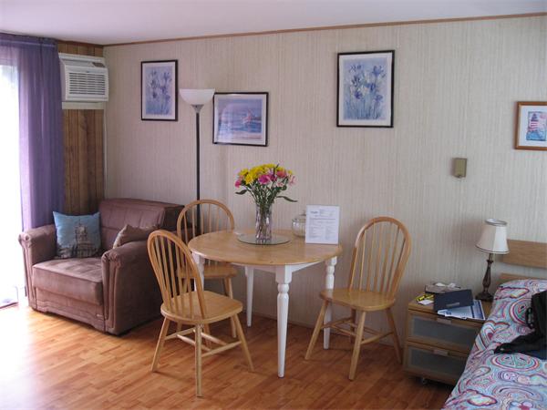 178 Captain Chase Road, Unit 12 Dennis, MA 02639 - Photo 4 of 4 a view of a dining room with furniture and wooden floor