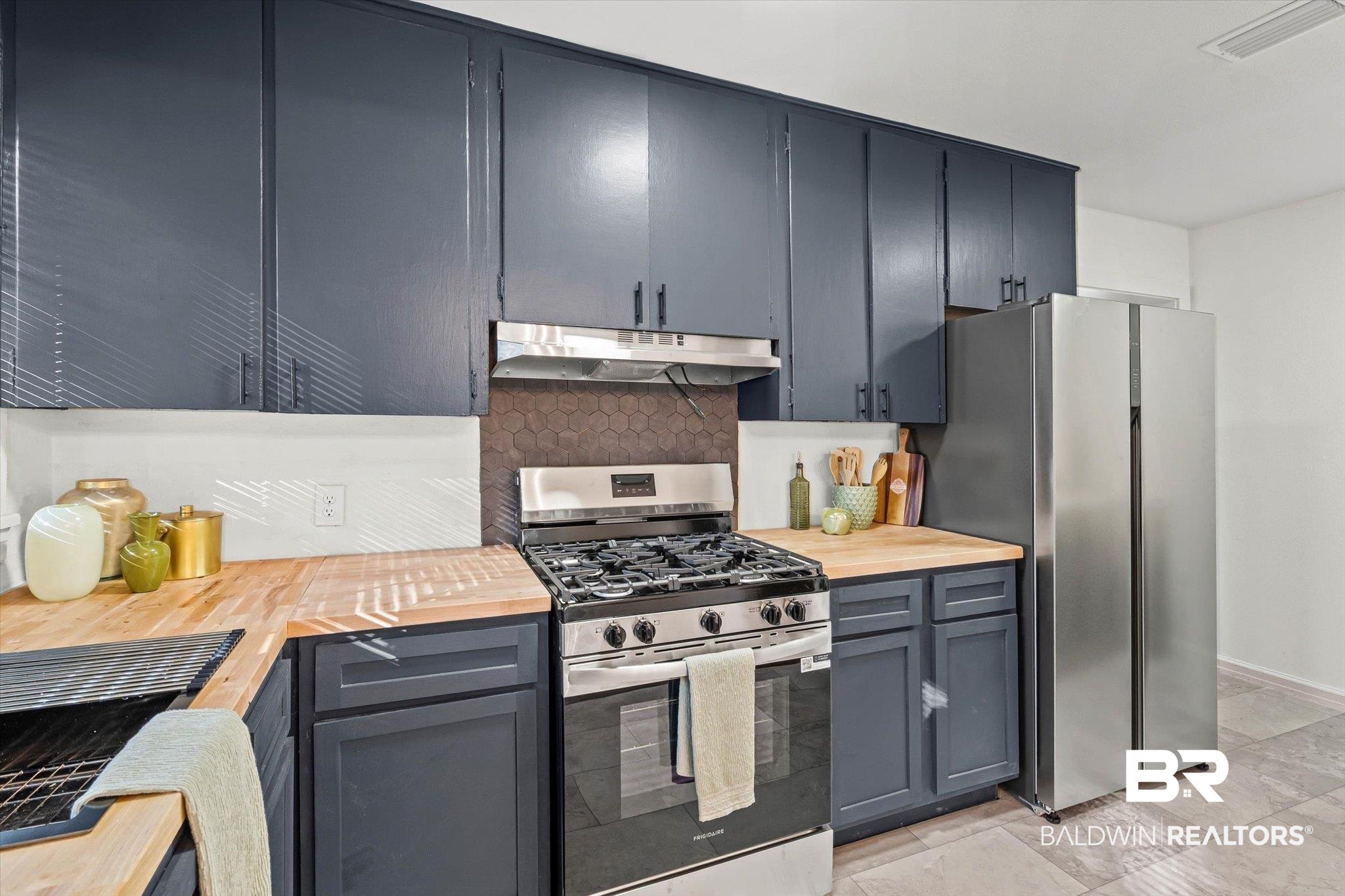2806 Exter Drive Mobile, AL 36606 - Photo 9 of 24 Kitchen featuring appliances with stainless steel finishes, wood counters, decorative backsplash, under cabinet range hood, and gray cabinets