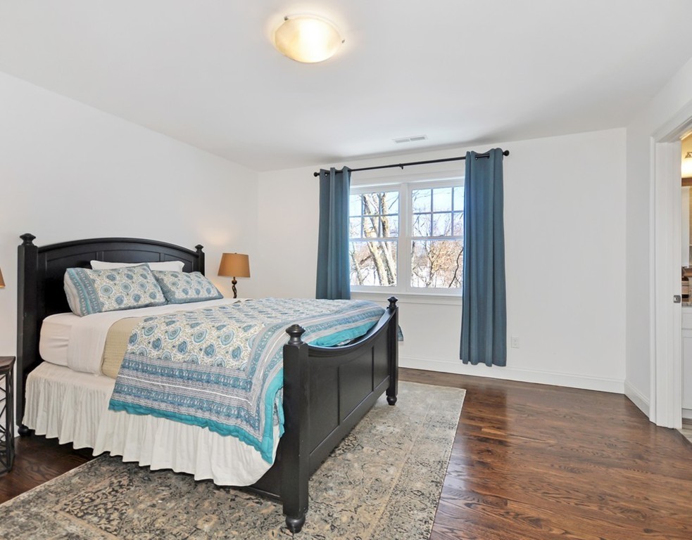 291 Monsen Road Concord, MA 01742 - Photo 21 of 26 a bedroom with a bed and wooden floor