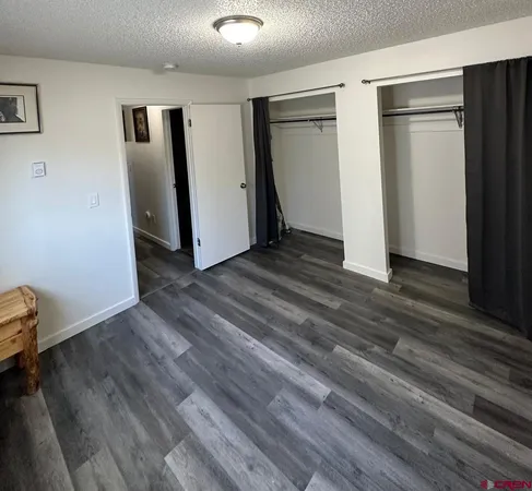 an empty room with wooden floor and closet