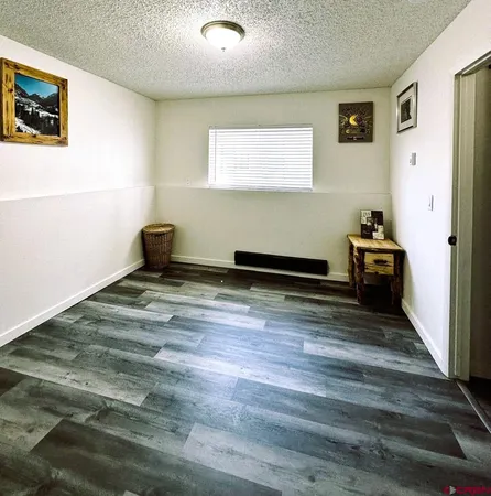 a room with a bed and wooden floor