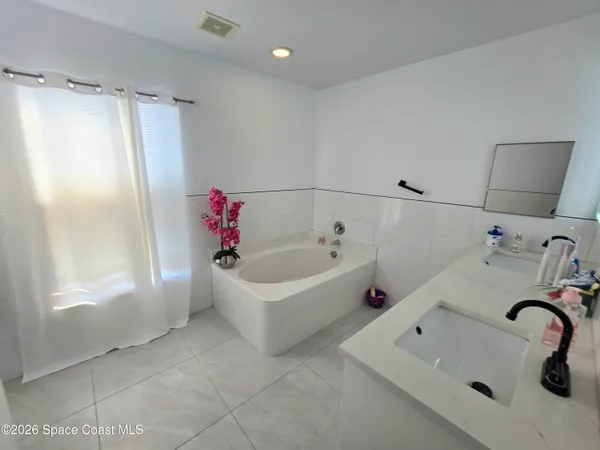 a bathroom with a tub sink and mirror