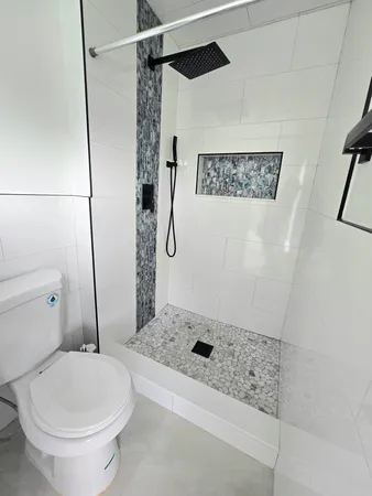 a bathroom with a sink a toilet and shower