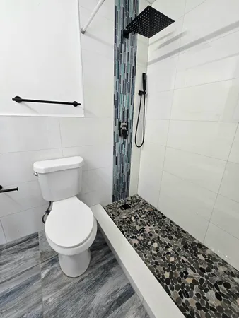 a bathroom with a toilet and a shower