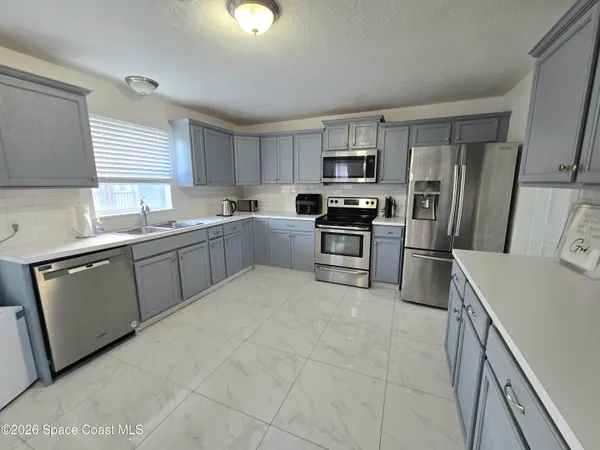 a kitchen with stainless steel appliances granite countertop a sink dishwasher stove top oven and refrigerator