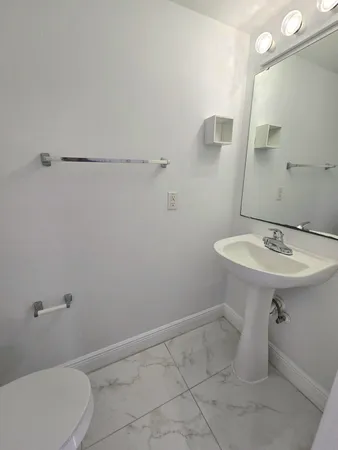 a bathroom with a sink toilet and a mirror