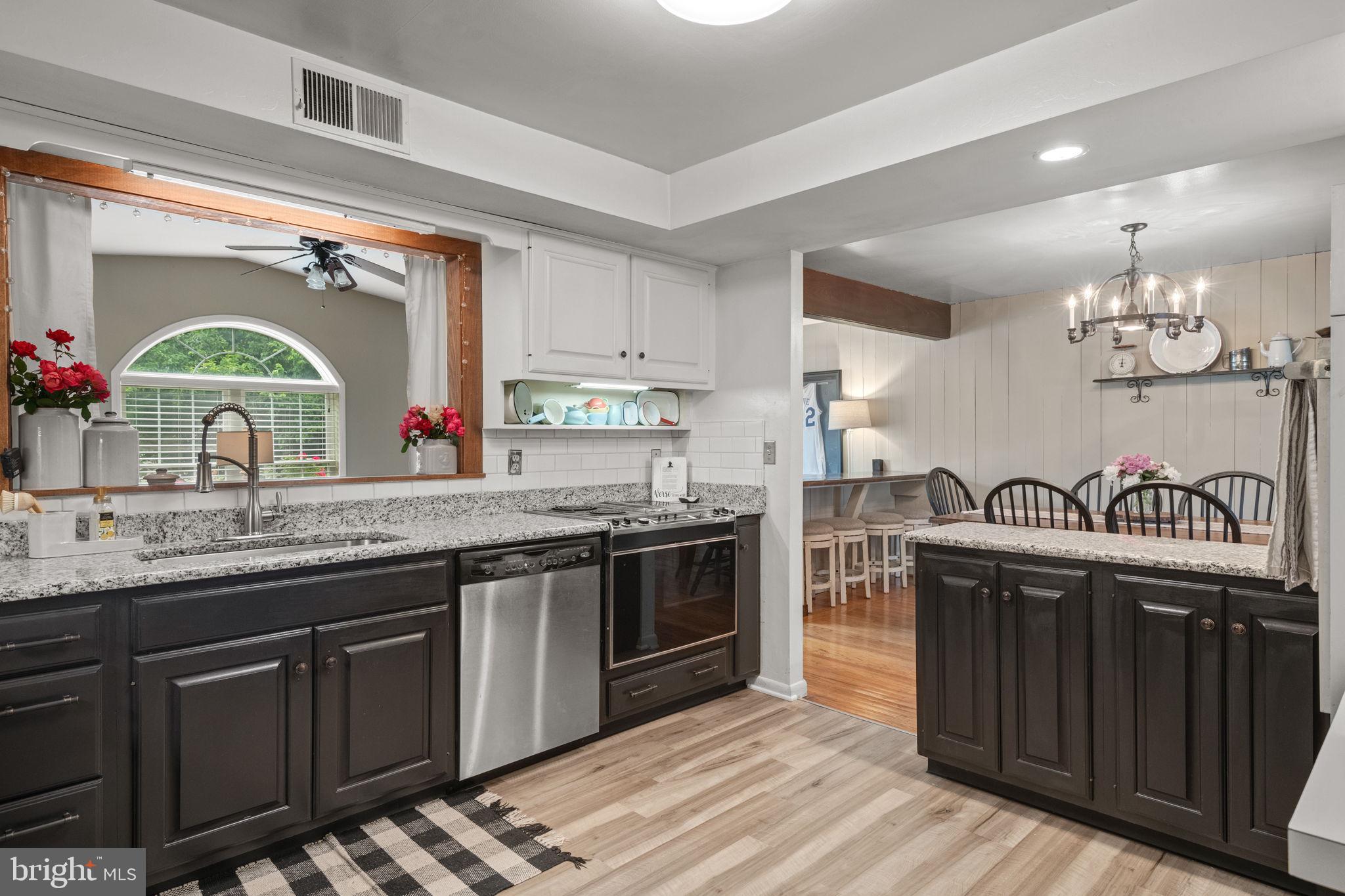 1818 Longview Drive Lancaster, PA 17601 - Photo 15 of 49 a kitchen with granite countertop a stove a sink dishwasher and cabinets with wooden floor