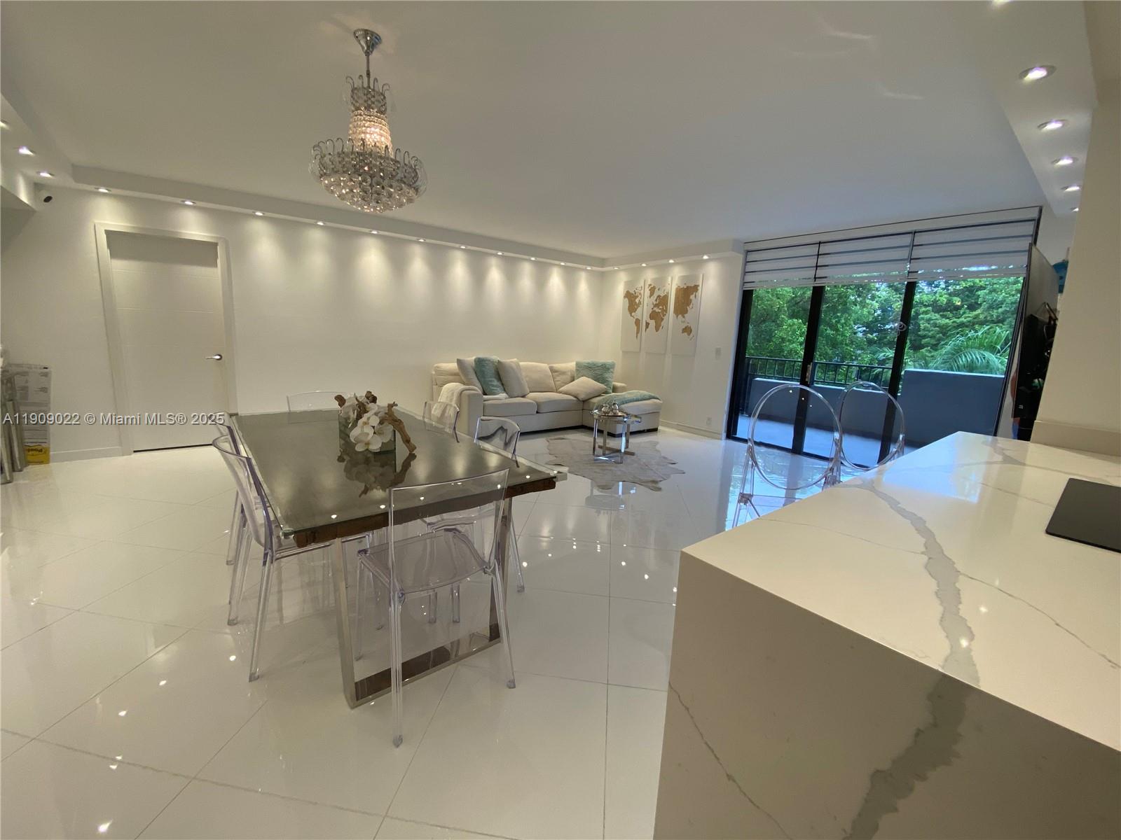 121 Crandon Boulevard, Unit 351 Key Biscayne, FL 33149 - Photo 4 of 15 a living room with furniture and a chandelier