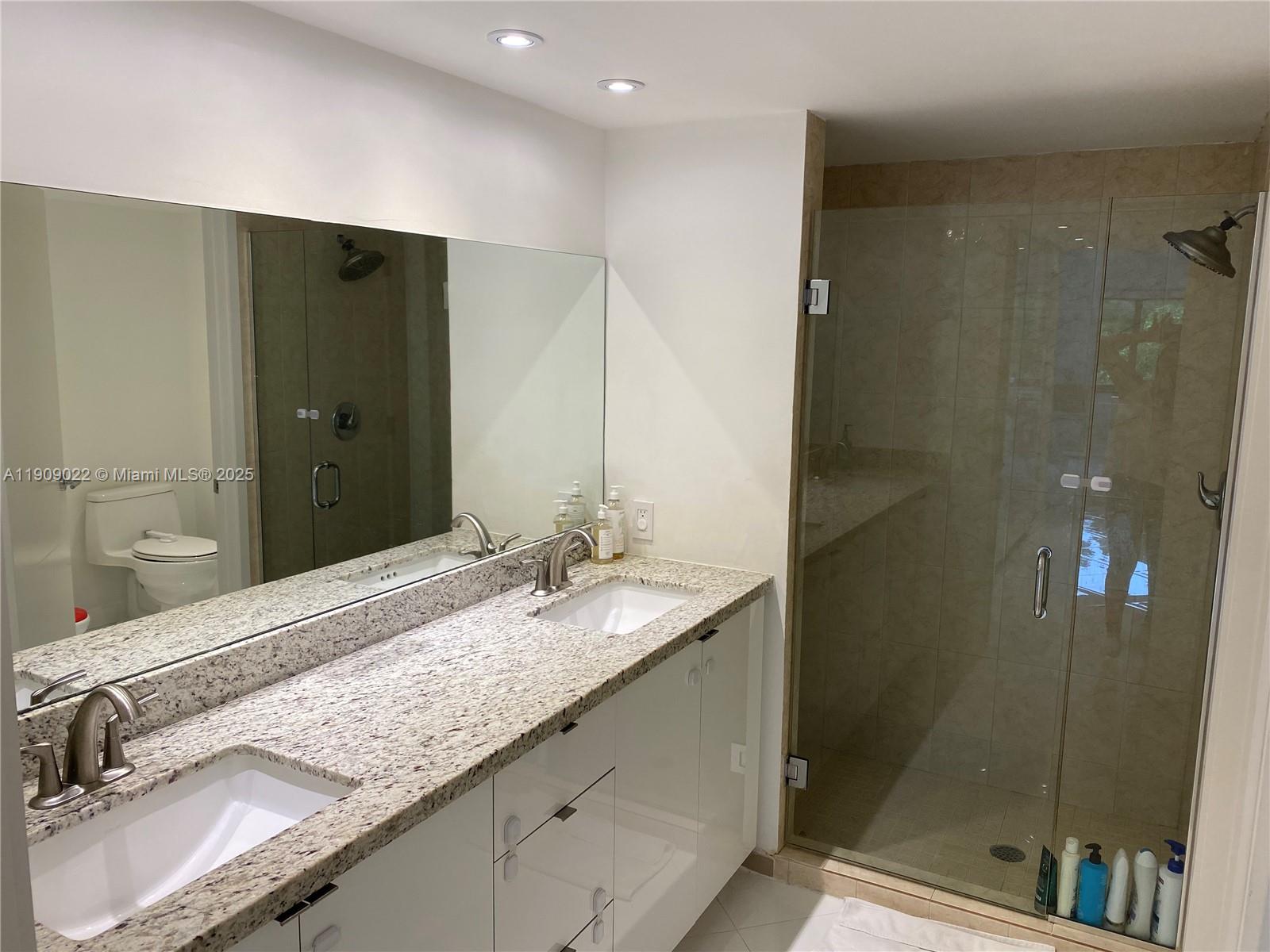 121 Crandon Boulevard, Unit 351 Key Biscayne, FL 33149 - Photo 9 of 15 a bathroom with a granite countertop sink and a mirror