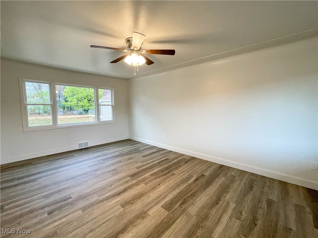 4949 East Radio Road Youngstown, OH 44515 - Photo 4 of 37 Unfurnished room with hardwood / wood-style flooring and ceiling fan