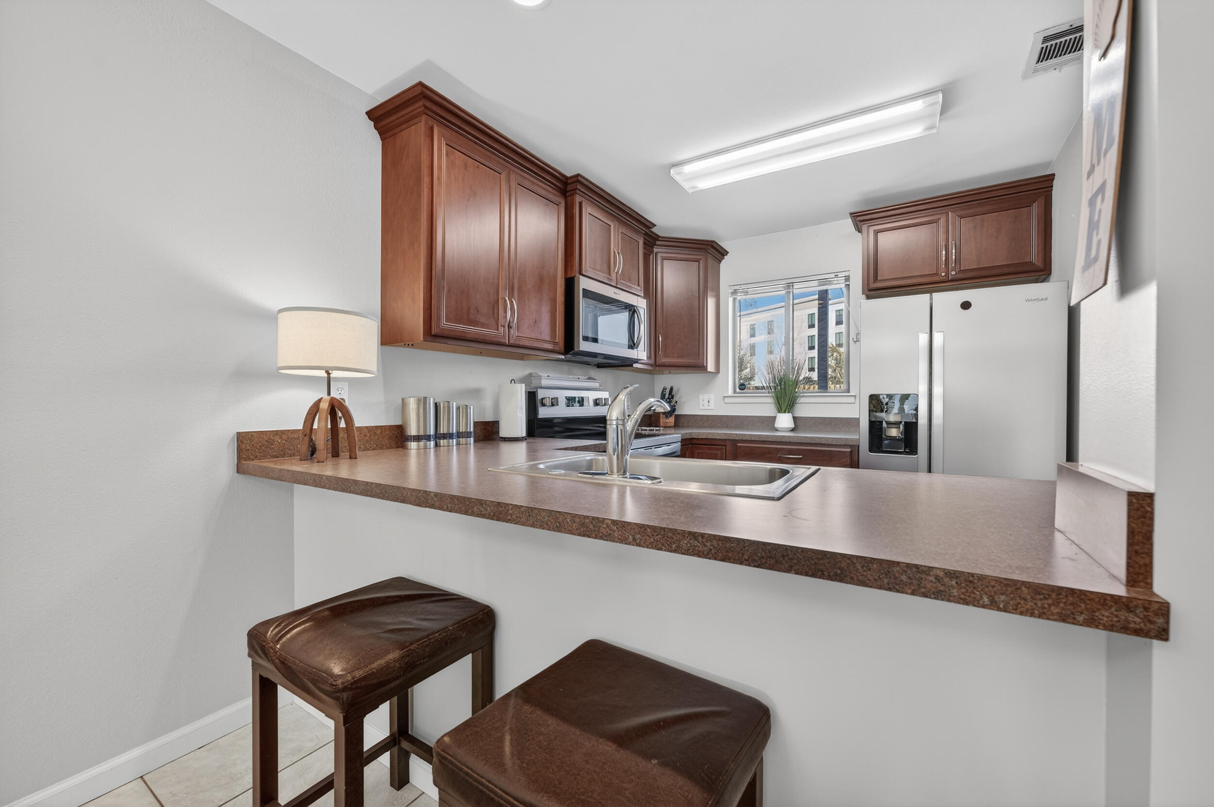 17620 Front Beach Road, Unit BB6 Panama City Beach, FL 32413 - Photo 12 of 47 a kitchen with stainless steel appliances granite countertop a sink refrigerator and microwave