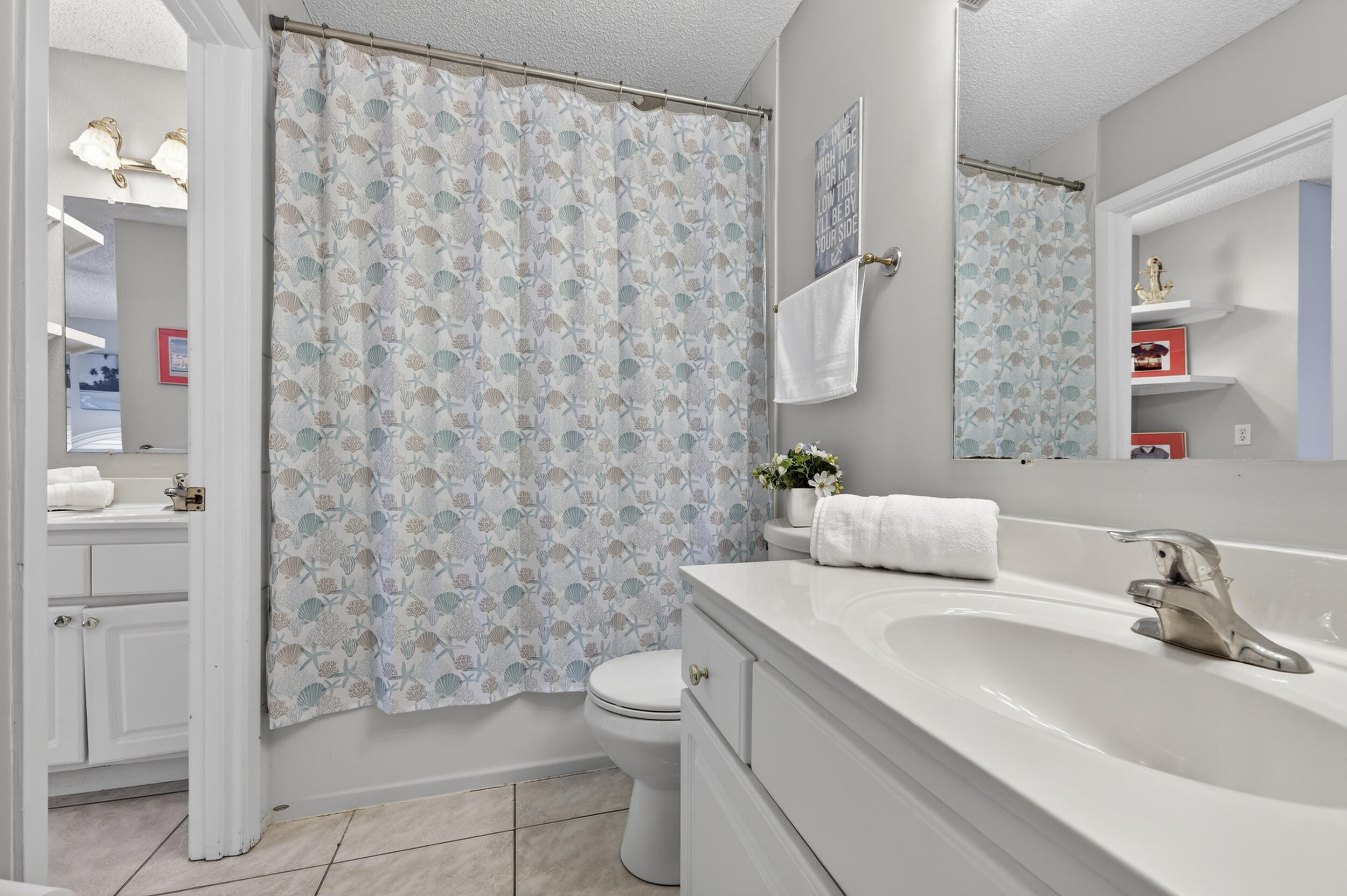 17620 Front Beach Road, Unit BB6 Panama City Beach, FL 32413 - Photo 30 of 47 a bathroom with a sink a toilet and shower curtain