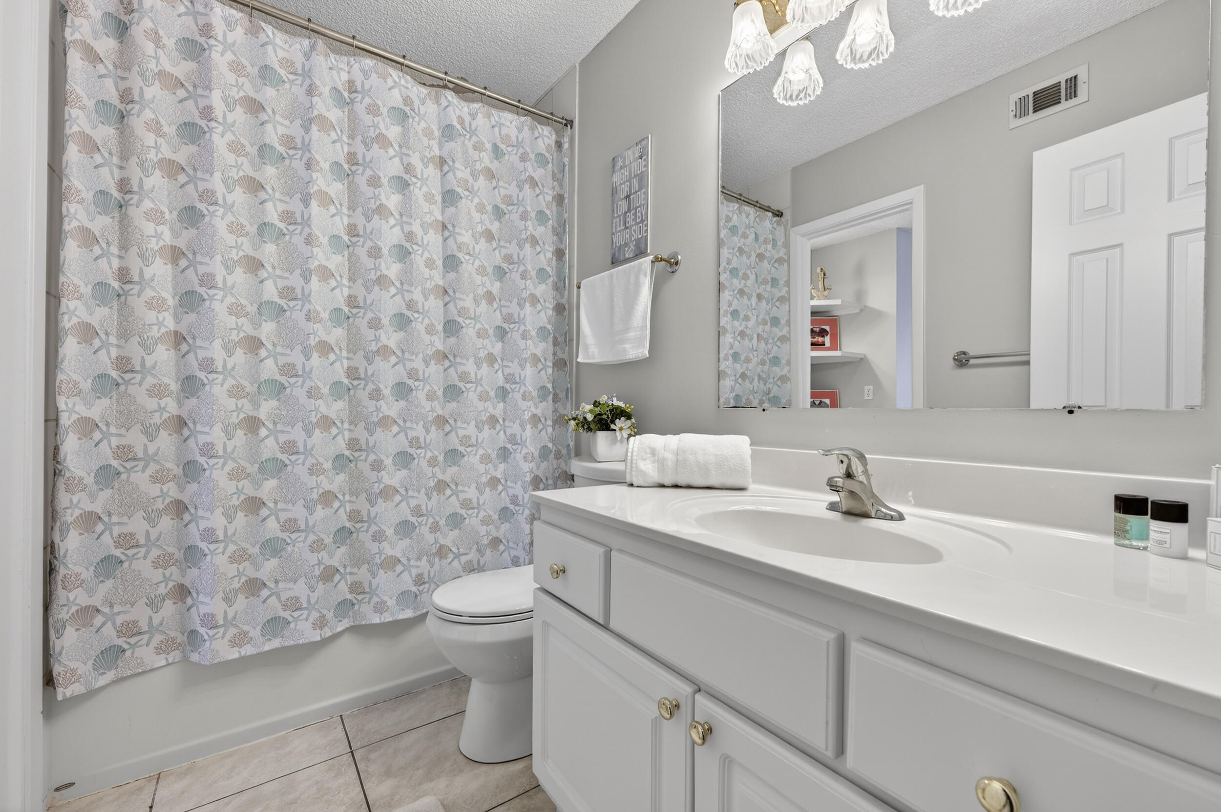 17620 Front Beach Road, Unit BB6 Panama City Beach, FL 32413 - Photo 31 of 47 a bathroom with a granite countertop sink a toilet and a mirror