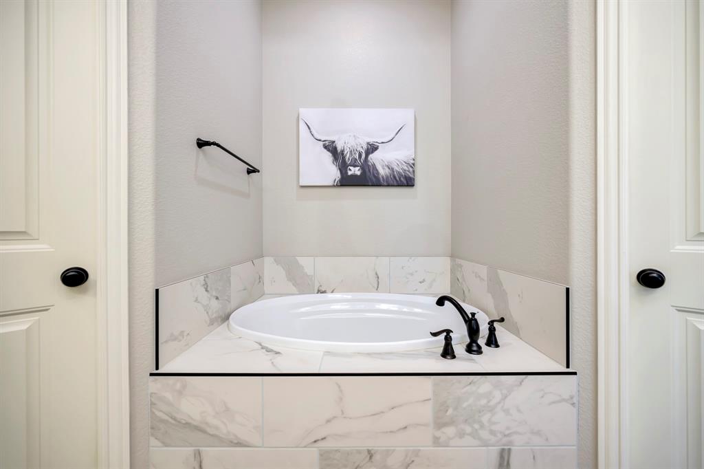 3224 North Cardinal Road Azle, TX 76020 - Photo 23 of 40 Integrated soaking tub featuring a white surround with marble-look tile and matte black fixtures
