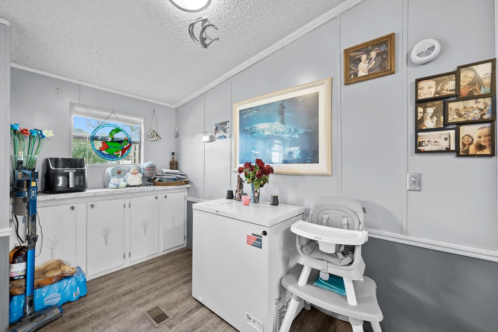 106 Lake Lane Crescent City, FL 32112 - Photo 10 of 25 a white kitchen with a sink cabinets and wooden floor