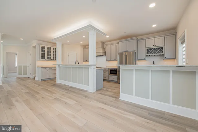 a large kitchen with stainless steel appliances granite countertop a lot of counter space and wooden floors