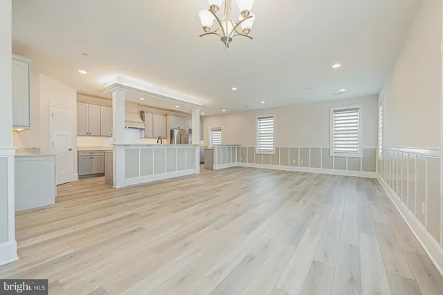 a large kitchen with granite countertop a large counter top a sink stainless steel appliances and cabinets