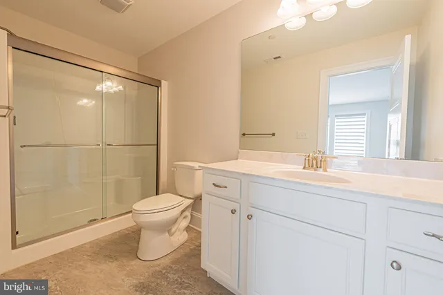 a bathroom with a toilet a sink a mirror a bathtub and vanity