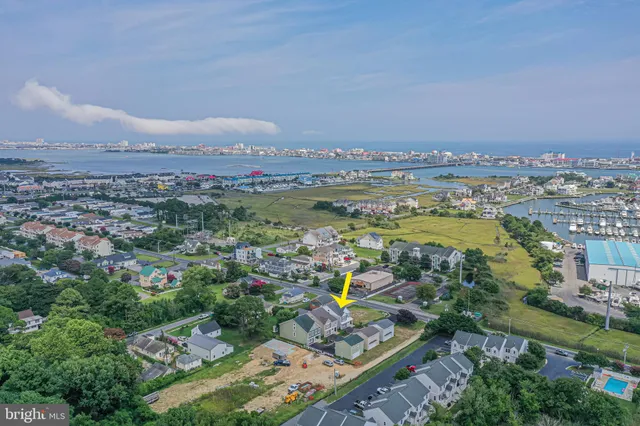 an aerial view of a city with lots of residential buildings and mountain view in back