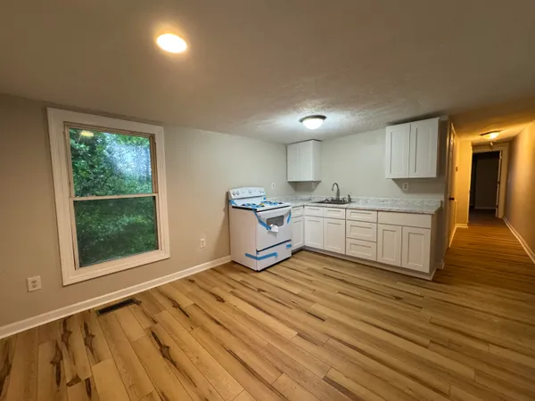 a kitchen with stainless steel appliances granite countertop a sink window and cabinets