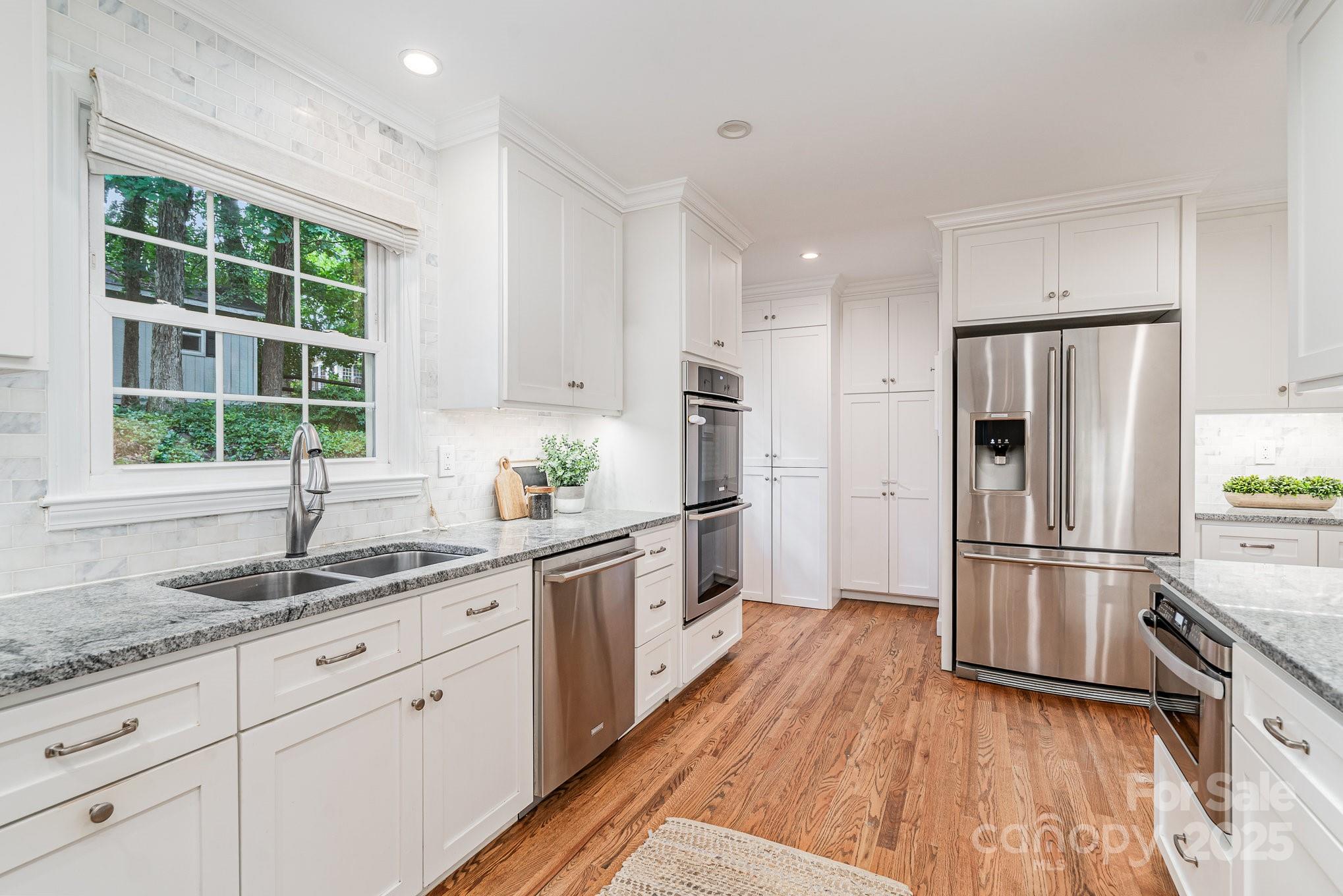 6749 Windyrush Road Charlotte, NC 28226 - Photo 13 of 30 a kitchen with a refrigerator wooden floor a sink and a window