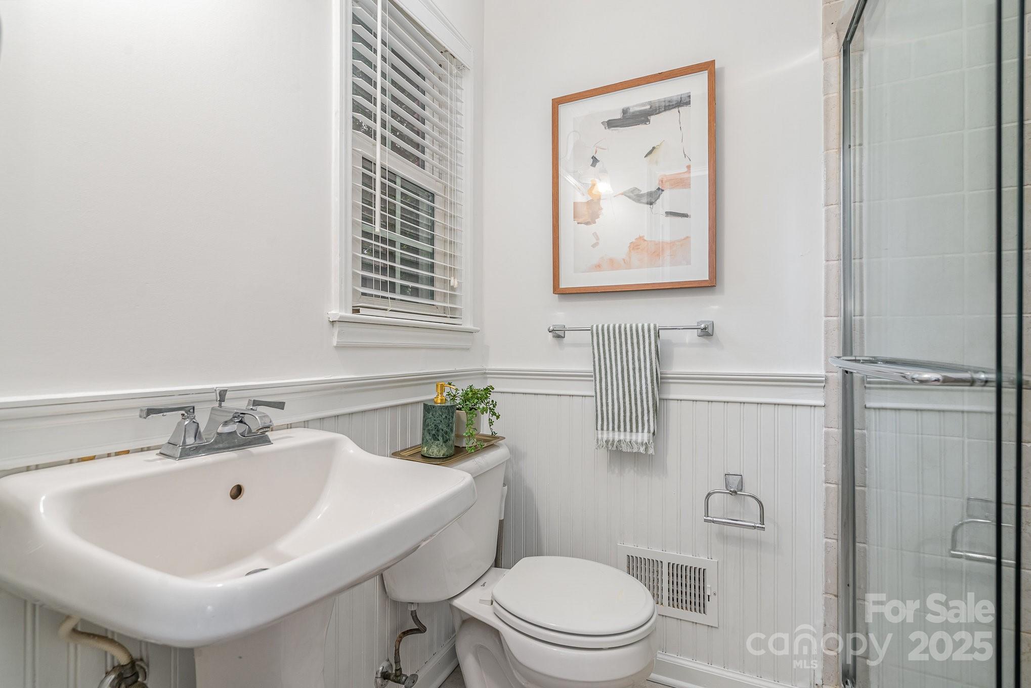 6749 Windyrush Road Charlotte, NC 28226 - Photo 18 of 30 a bathroom with a toilet a sink and mirror
