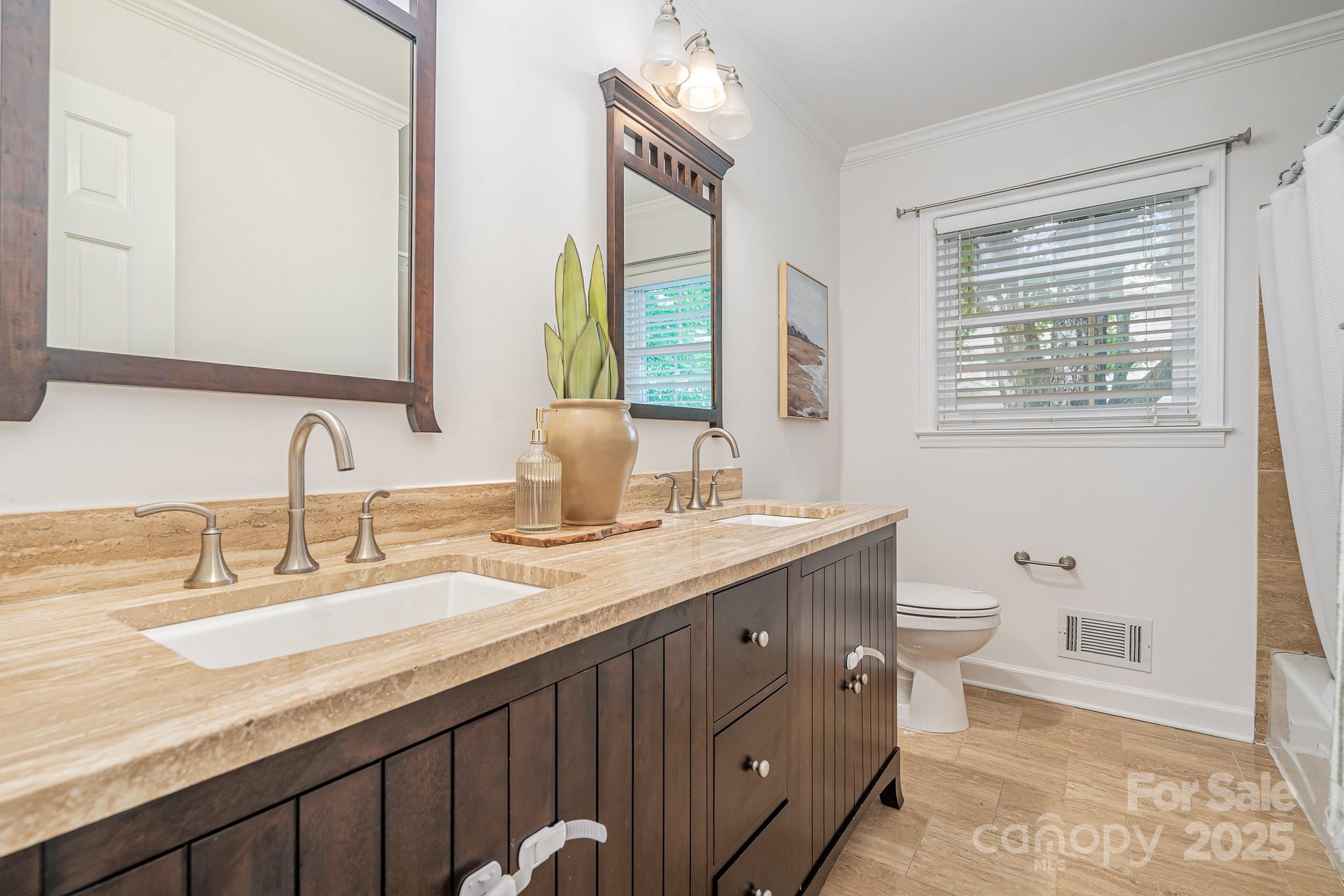 6749 Windyrush Road Charlotte, NC 28226 - Photo 21 of 30 a bathroom with double vanity sink a mirror and a toilet