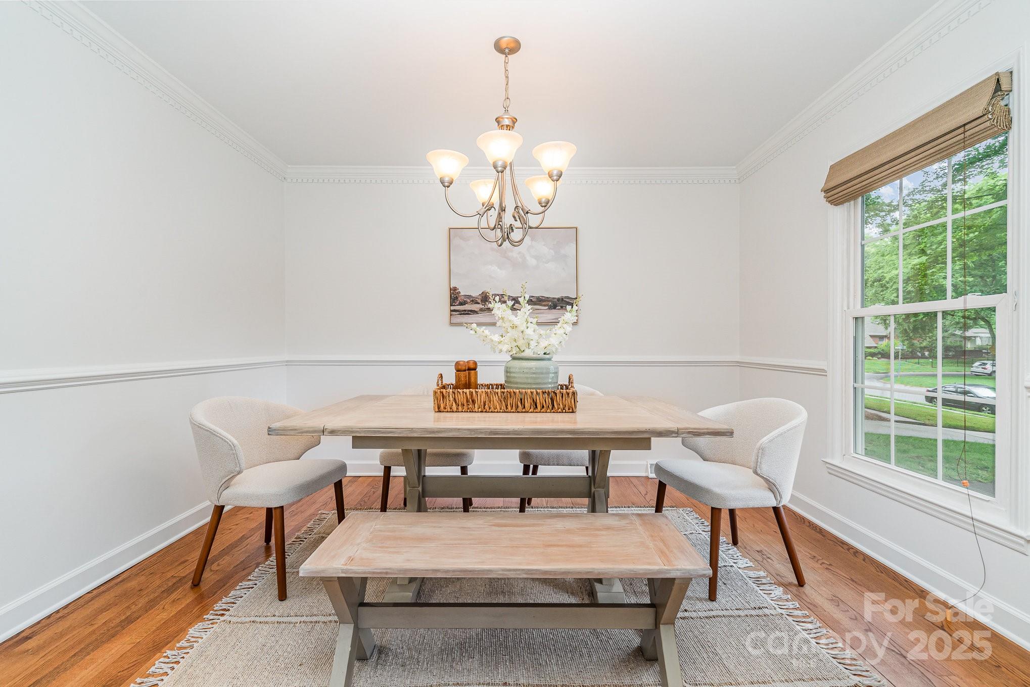 6749 Windyrush Road Charlotte, NC 28226 - Photo 7 of 30 a view of a dining room with furniture a chandelier and wooden floor