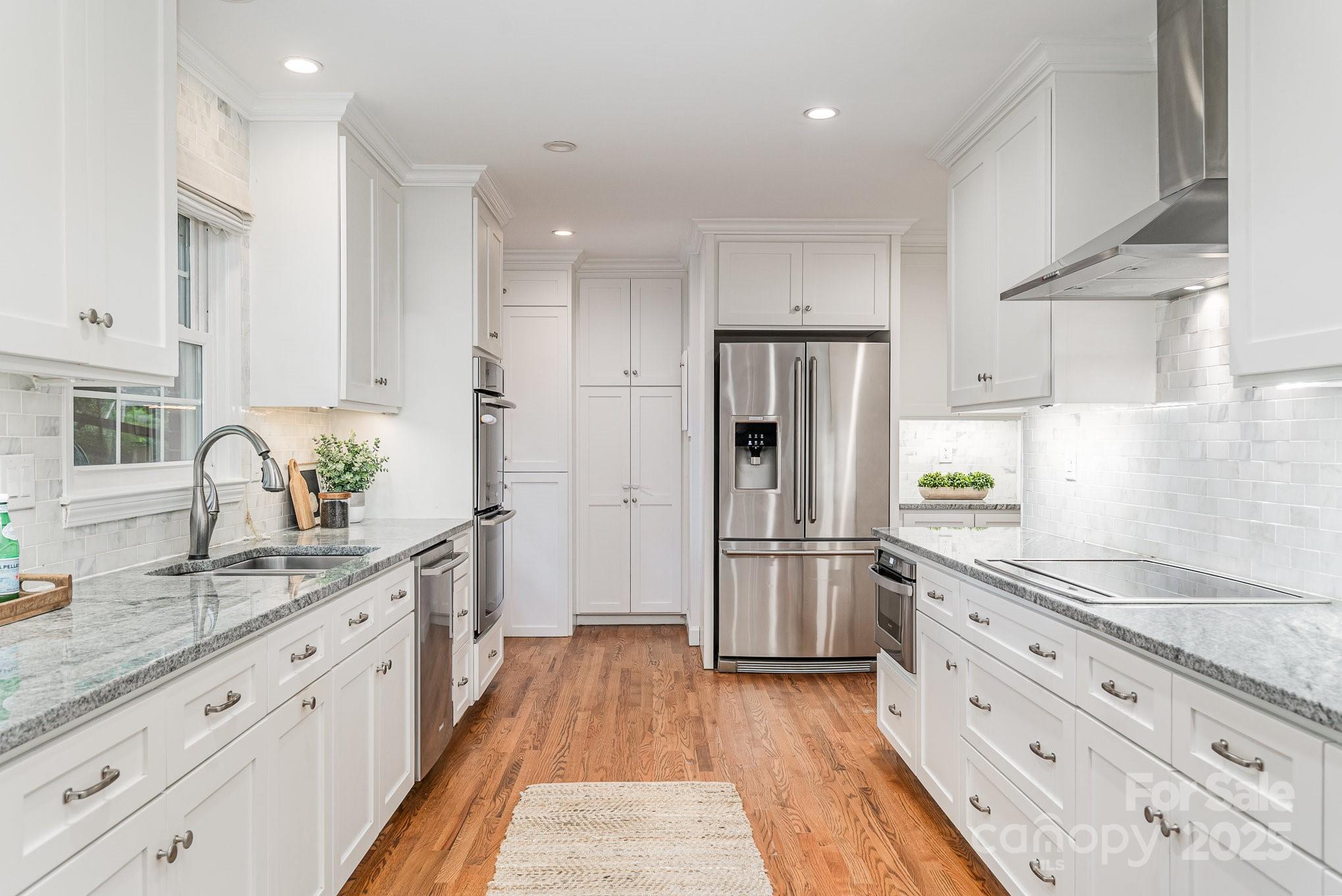 6749 Windyrush Road Charlotte, NC 28226 - Photo 10 of 30 a kitchen with stainless steel appliances white cabinets and wooden floors